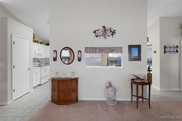 hall featuring light carpet and lofted ceiling