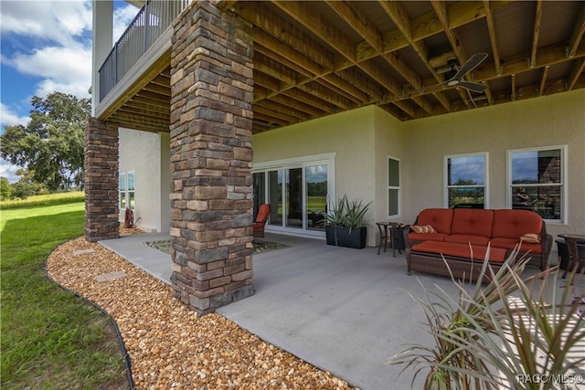 view of patio featuring ceiling fan, a balcony, and an outdoor living space