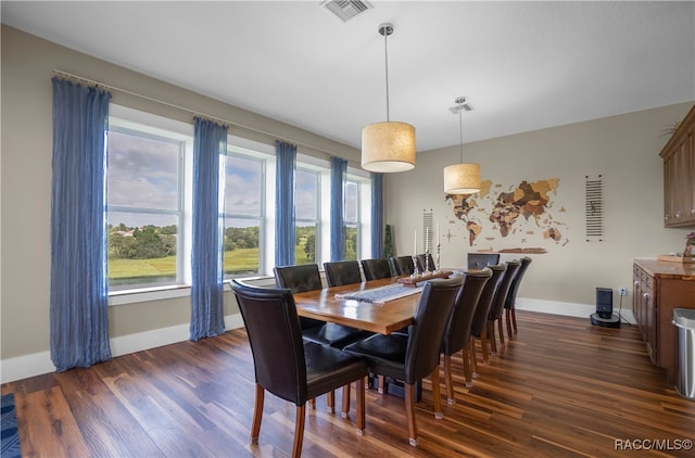 dining space with dark wood-style floors, visible vents, and baseboards