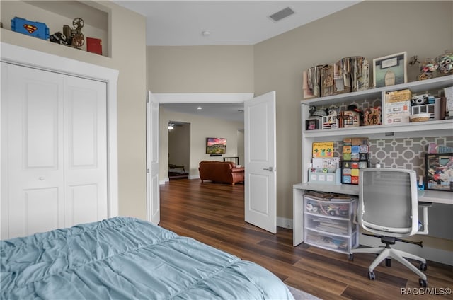 bedroom with baseboards, a closet, visible vents, and wood finished floors