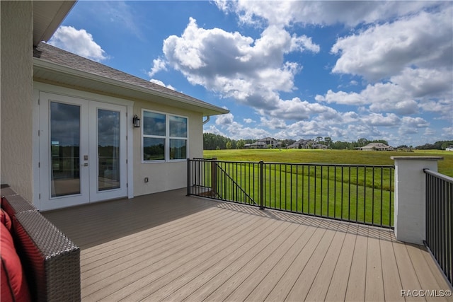 deck with french doors and a lawn