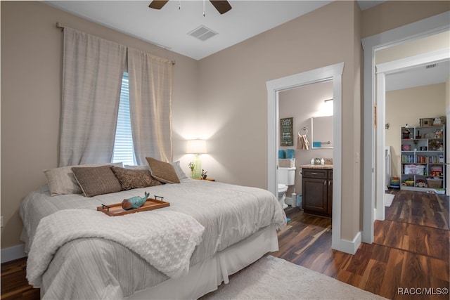 bedroom featuring baseboards, visible vents, dark wood-style flooring, and ensuite bathroom