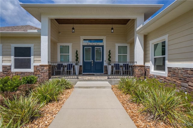 property entrance with stone siding and a porch