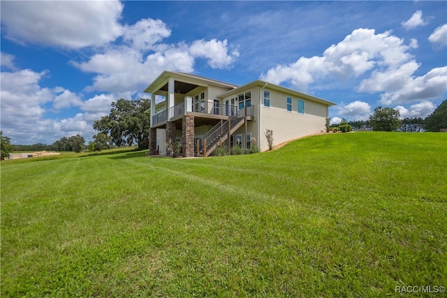 back of property featuring stucco siding, stairs, a deck, and a yard