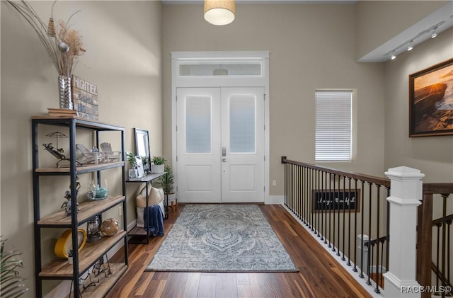 entrance foyer featuring baseboards, wood finished floors, and track lighting