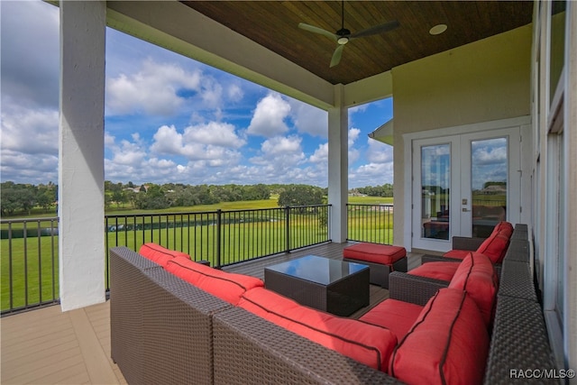 deck featuring a rural view, an outdoor living space, and a ceiling fan