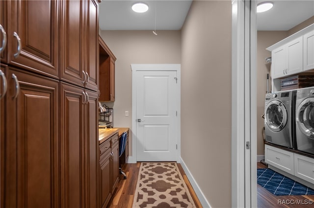 clothes washing area featuring cabinet space, baseboards, separate washer and dryer, and dark wood-style flooring