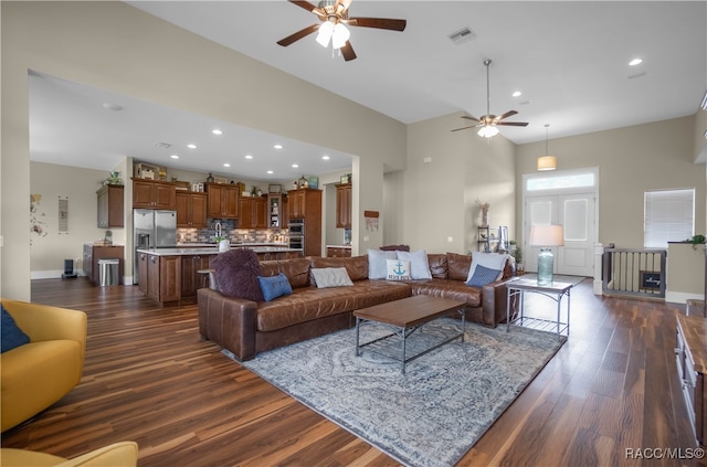 living room featuring baseboards, visible vents, dark wood-type flooring, and recessed lighting