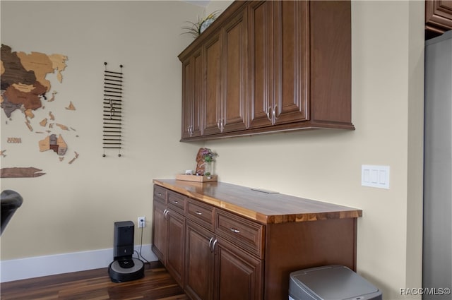 interior space featuring baseboards and dark wood-style flooring