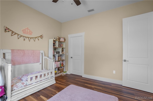 bedroom with a ceiling fan, wood finished floors, visible vents, and baseboards