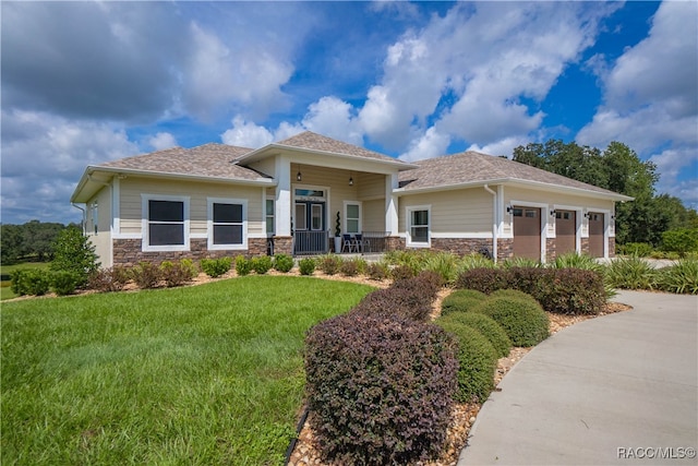 view of front of home with a garage, a front yard, stone siding, and driveway