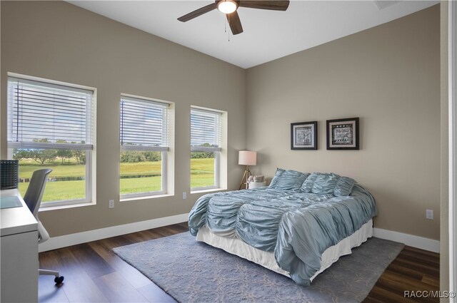 bedroom with dark wood-type flooring, baseboards, and a ceiling fan