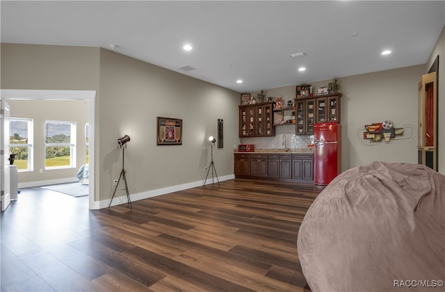 bar featuring recessed lighting, dark wood-style flooring, a sink, tasteful backsplash, and indoor wet bar