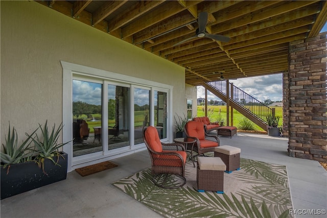 view of patio featuring stairs and a ceiling fan