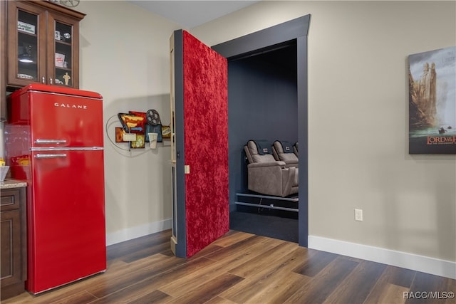 interior space featuring baseboards, wood finished floors, and freestanding refrigerator