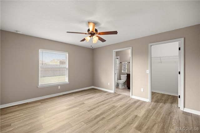 176 Juniper Loop Cir, Ocala, FL 34480 - unfurnished bedroom featuring light wood-style floors, a spacious closet, ensuite bathroom, baseboards, and a closet