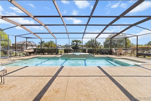 view of swimming pool featuring a lanai, a pool with connected hot tub, and a patio area