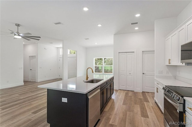 kitchen featuring a center island with sink, white cabinetry, appliances with stainless steel finishes, and sink