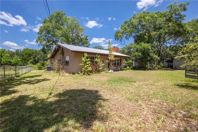 8915 E Echo Ct, Inverness, FL 34450 - back of property with central AC, metal roof, and a chimney