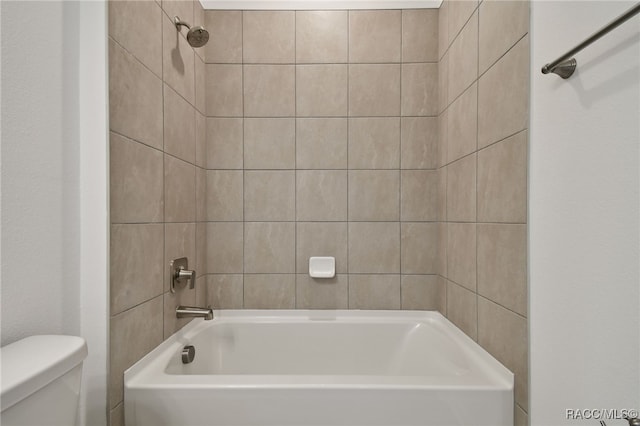 bathroom featuring tiled shower / bath and toilet