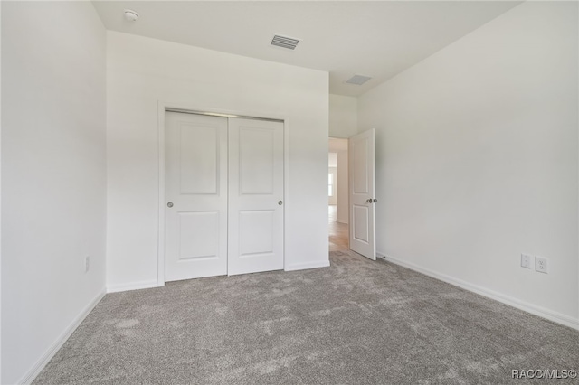 unfurnished bedroom featuring carpet flooring and a closet