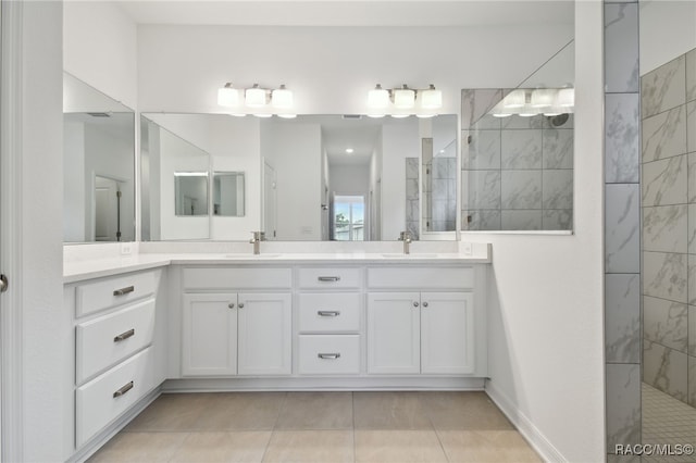 bathroom with tile patterned flooring, vanity, and a tile shower