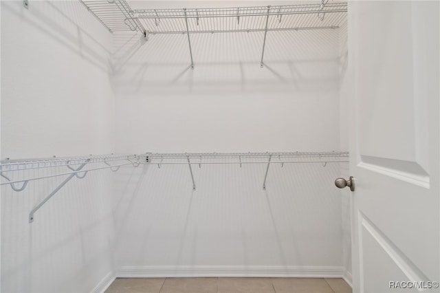 spacious closet with light tile patterned floors