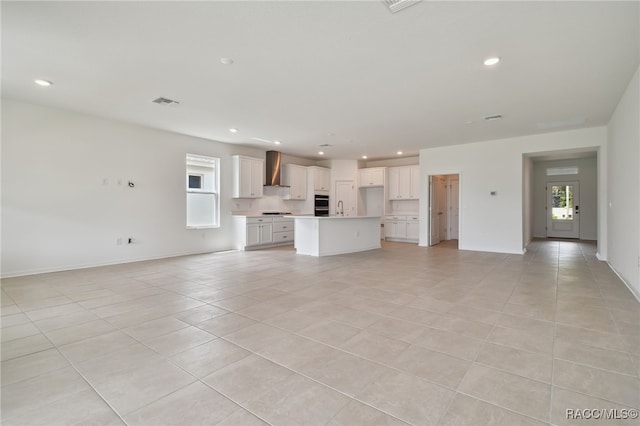 unfurnished living room featuring light tile patterned floors and sink