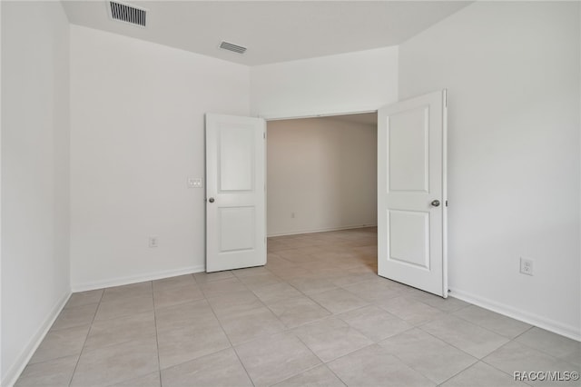 spare room featuring light tile patterned flooring