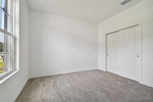 unfurnished bedroom with carpet floors and a closet