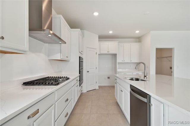 kitchen with white cabinets, sink, stainless steel appliances, and wall chimney range hood