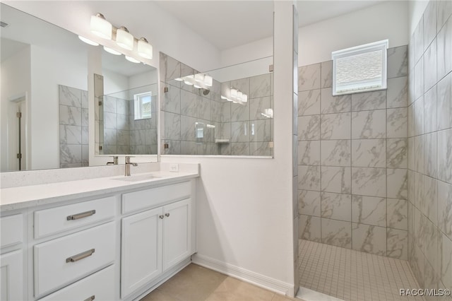 bathroom featuring a tile shower, tile patterned floors, and vanity