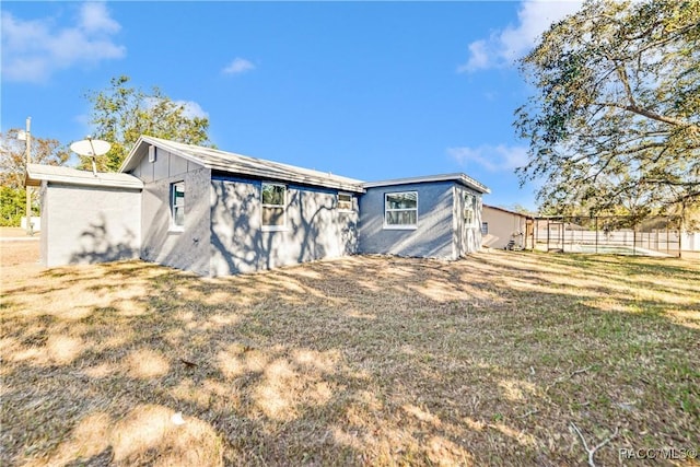 rear view of house featuring a yard