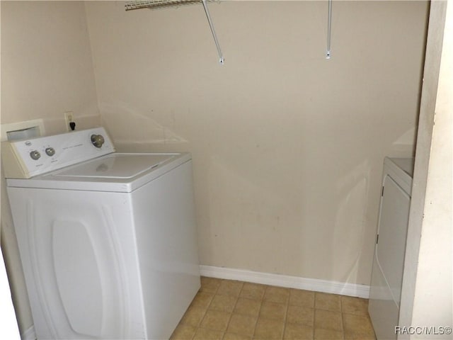 clothes washing area with washer / clothes dryer and light tile patterned floors