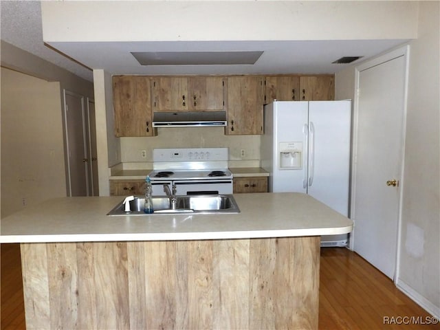 kitchen with sink, white appliances, hardwood / wood-style flooring, and range hood