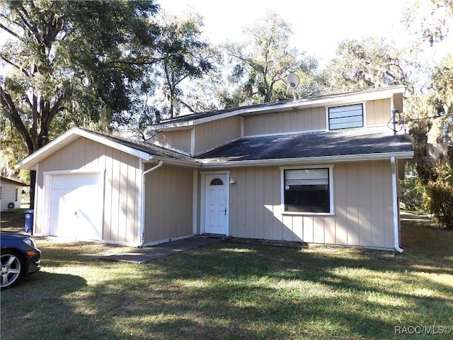 view of property featuring a front lawn and a garage