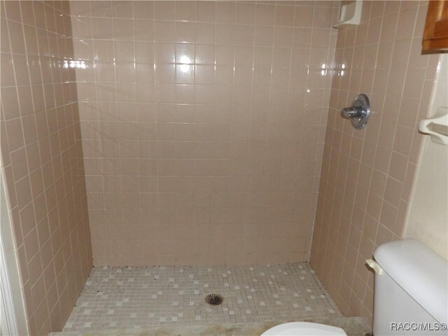 bathroom featuring toilet and tiled shower