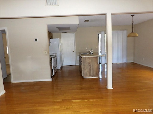 kitchen featuring light hardwood / wood-style floors, stainless steel electric range oven, hanging light fixtures, and sink