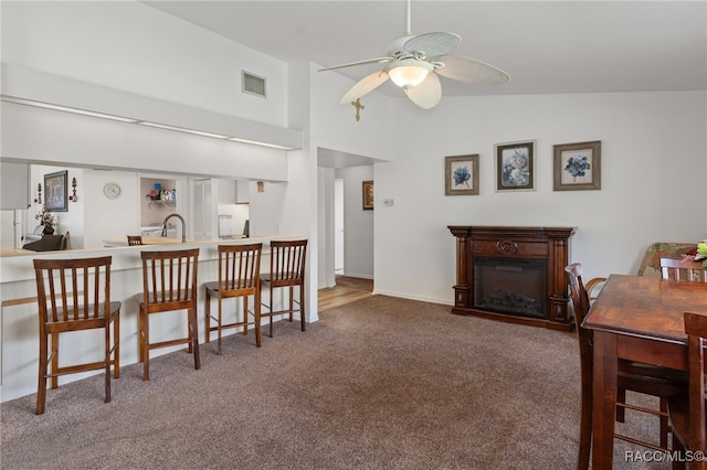 interior space with carpet flooring, ceiling fan, sink, and vaulted ceiling