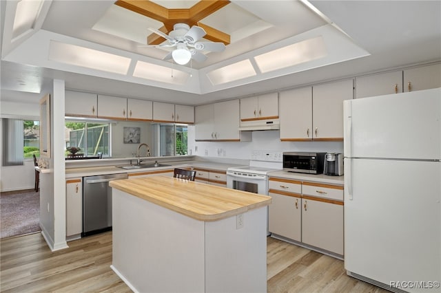 kitchen with sink, stainless steel appliances, a kitchen island, light hardwood / wood-style flooring, and white cabinets