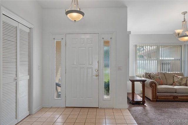 tiled foyer with an inviting chandelier