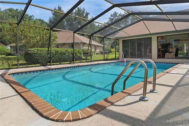 outdoor pool with glass enclosure and a patio area