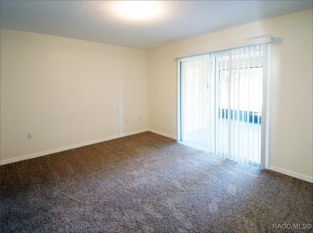 carpeted empty room featuring a textured ceiling