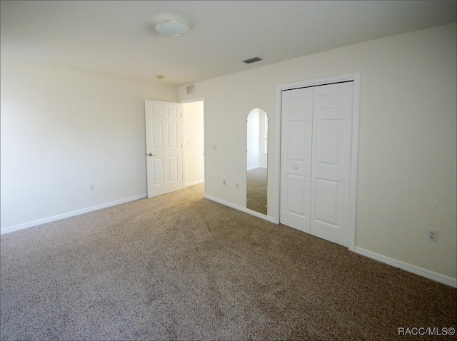 unfurnished bedroom with carpet flooring and a closet