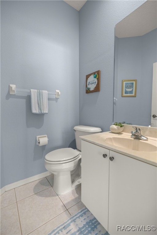 bathroom featuring tile patterned flooring, vanity, and toilet