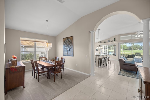 dining area with ceiling fan with notable chandelier, decorative columns, vaulted ceiling, and light tile patterned flooring