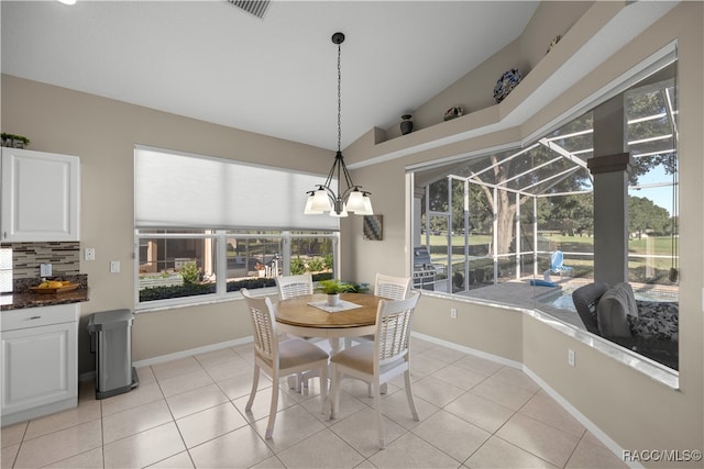 tiled dining area with a chandelier and lofted ceiling