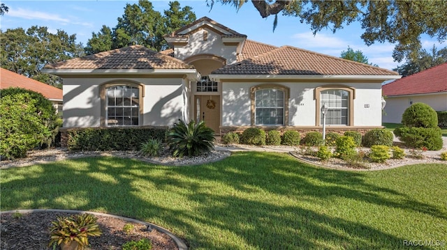 mediterranean / spanish-style home with a front yard