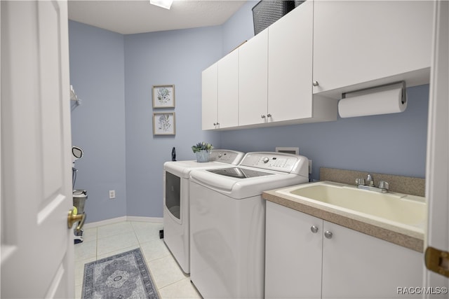 clothes washing area with sink, light tile patterned floors, cabinets, and independent washer and dryer