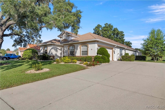 mediterranean / spanish home featuring a garage and a front lawn